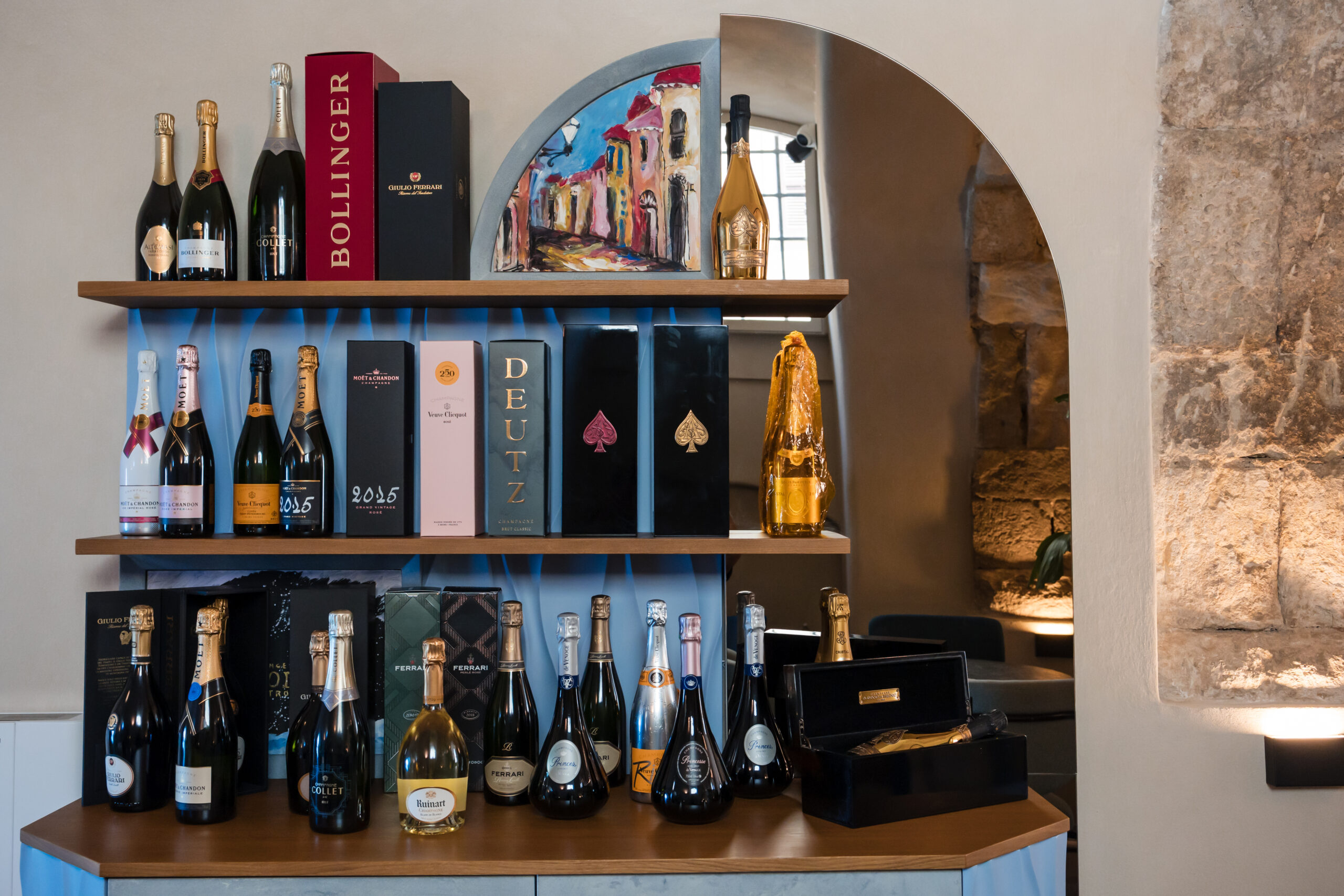 Interni del ristorante Deodato Lounge Bistrot di Tropea con vista di un mobiletto di design, con uno specchio sul lato destro e alcune bottiglie di Champagne